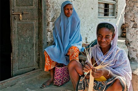 simsearch:862-03737306,k - Tanzania, Zanzibar. Watched by her daughter, a Zanzibari woman weaves palm fronds to make baskets in Paje village. Fotografie stock - Rights-Managed, Codice: 862-03737283