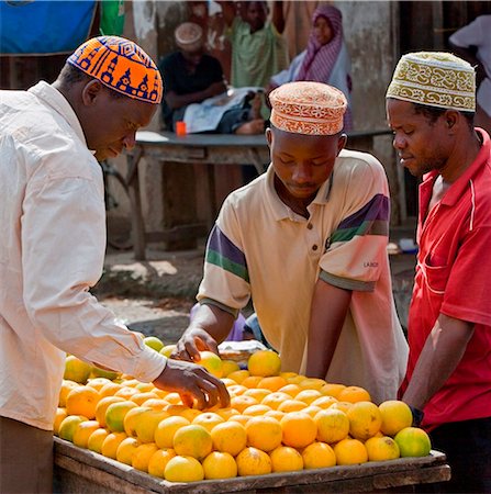 simsearch:862-08718720,k - Tanzania, Zanzibar. Shoppers select locally-grown oranges from a stall at Mkokotoni Market in the northwest of Zanzibar Island. Stock Photo - Rights-Managed, Code: 862-03737296