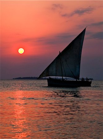 simsearch:862-03737248,k - Tanzania, Zanzibar. A dhow sails back to Zanzibar harbour at sunset. Stock Photo - Rights-Managed, Code: 862-03737308