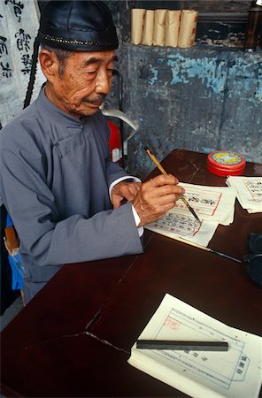 China, Shanxi Province, Pingyao. An 'actor' assumes the role of a 19th-century bank clerk in one of Pingyaos' former banks. Fotografie stock - Rights-Managed, Codice: 862-03731106