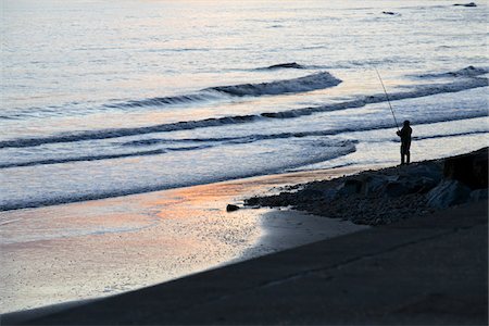 england beach one person - England, Dorset. Lone angler fishing in Lyme Bay from the beach at Charmouth. Stock Photo - Rights-Managed, Code: 862-03731222