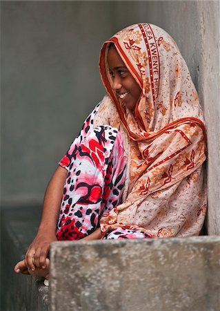 Kenia. Ein muslimisches Mädchen aus Lamu gemütlich auf der Steinbank an der Veranda Eingang in ihr Haus. Stockbilder - Lizenzpflichtiges, Bildnummer: 862-03731529