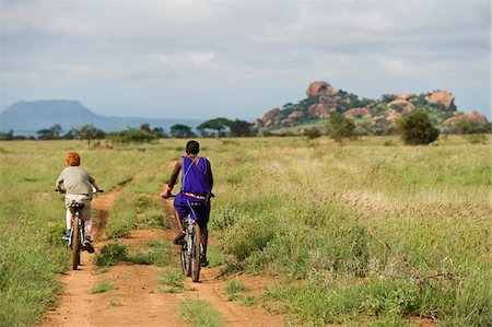 simsearch:862-05999409,k - Kenya, Chyulu Hills, Ol Donyo Wuas.  A Maasai guide takes a child on a mountain biking safari. Stock Photo - Rights-Managed, Code: 862-03731636