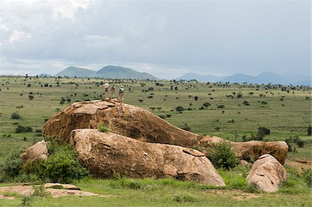 safaris - Kenya, Chyulu Hills, Ol Donyo Wuas.  A family on a bush walk climb up onto a kopje for a view over the plains.. Foto de stock - Con derechos protegidos, Código: 862-03731650
