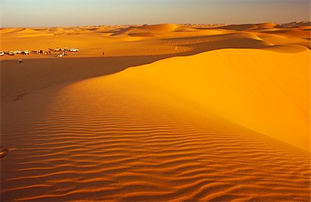 Libya, Fezzan, Erg Uan Kasa. Tourists set up a wild campsite in the midst of the Erg Uan Kasa dunes between the Jebel Akakus and the Messak Settafet. Fotografie stock - Rights-Managed, Codice: 862-03731761