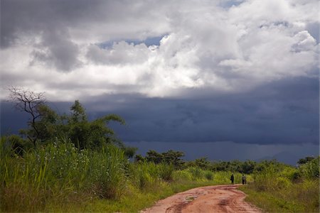 simsearch:862-08091518,k - Mozambique, Province de Nampula. Gens du pays descendre la piste rouge, devant l'orage qui s'approche. Photographie de stock - Rights-Managed, Code: 862-03731868