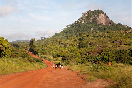 footstep in dirt - Mozambique, near Nampula. Children walk down the bright red earth road to school. Stock Photo - Rights-Managed, Code: 862-03731903