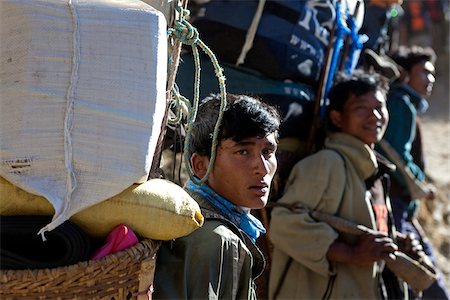 porter - Nepal, Everest Region, Khumbu Valley. Porters on a trek in the Khumbu Valley resting on the side of the Everest Base Camp trail. Stock Photo - Rights-Managed, Code: 862-03731939