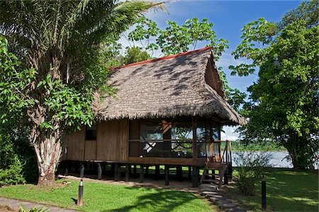 Pérou. Un cottage au toit de chaume chambres Pérou, Inkaterra Reserva Amazonica Lodge, sur les rives du fleuve Madre de Dios. Photographie de stock - Rights-Managed, Code: 862-03732016