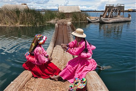 peruvian people - Peru, Two girl from Uros row a reed boat to one of the unique floating islands of Lake Titicaca. Stock Photo - Rights-Managed, Code: 862-03732107