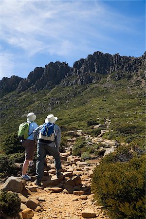 simsearch:862-03731805,k - Australia, Tasmania, Cradle Mountain-Lake St Clair National Park.  Hikers on the summit trail, with the peaks of Cradle Mountain in the distance. Foto de stock - Con derechos protegidos, Código: 862-03807273
