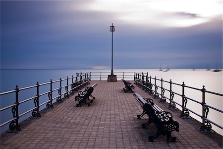 swanage - England, Dorset, Swanage. Sonnenaufgang von der Banjo-Anlegestelle in Swanage, mit der Isle Of Wight, die gerade am Horizont sichtbar. Stockbilder - Lizenzpflichtiges, Bildnummer: 862-03807375