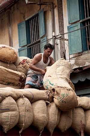 simsearch:862-03807550,k - Cochin, Indien. Ein Mann schleppt sich große Säcke mit Chili auf die Rückseite eines LKW. Stockbilder - Lizenzpflichtiges, Bildnummer: 862-03807537
