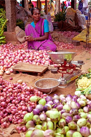 India, Chettinad. An onion and aubergine seller has done her best to match her produce at a Chettinad market. Stock Photo - Rights-Managed, Code: 862-03807555