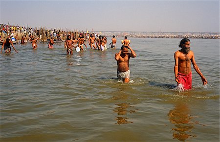 India, Uttar Pradesh, Allahabad. Groups of sadhus, or Hindu ascetics, wade into the River Ganges during the celebrated Kumbh Mela festival which is held here every twelve years. Stock Photo - Rights-Managed, Code: 862-03807585