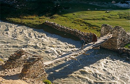 simsearch:862-03807589,k - India, Jammu & Kashmir, Ladakh, Zanskar, Kargyak Valley. A Zanskari man and monk cross the Kargyak River on a traditional wood and masonry suspension bridge. Stock Photo - Rights-Managed, Code: 862-03807598