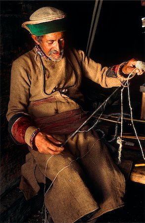 simsearch:862-03807589,k - India, Himachal Pradesh, Kinnaur, Baspa Valley, Kamru. A Kinnauri man wearing a traditional Kinnauri hat prepares skeins of wool for weaving. Stock Photo - Rights-Managed, Code: 862-03807618