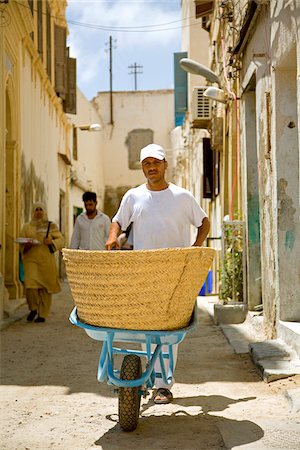 photos of old arab men - Tripoli, Libya; A man carrying a wheelbarrow through the steets of the old Medina Stock Photo - Rights-Managed, Code: 862-03807886