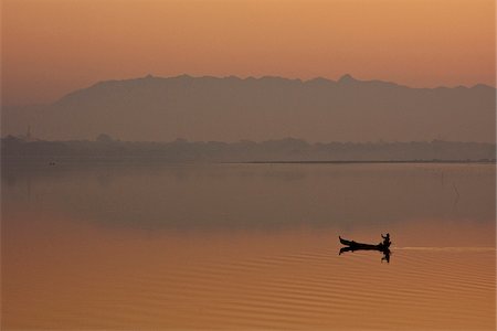 row boat canoe - Myanmar, Burma, Amarapura. A fisherman paddling across Taungthaman Lake at sunrise, Amarapura. Stock Photo - Rights-Managed, Code: 862-03807949