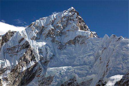 Nepal, Everest Region, Khumbu Valley. A helicopter having carried out a rescue from the Everest Base Camp is dwarfed by the Everest Massif on its return to Kathmandu Stock Photo - Rights-Managed, Code: 862-03808039