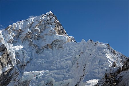 La vallée de Khumbu au Népal, région de l'Everest. Un hélicoptère qu'après avoir effectué un sauvetage de l'Everest Base Camp est éclipsé par le Massif de l'Everest à son retour à Kathmandu Photographie de stock - Rights-Managed, Code: 862-03808040