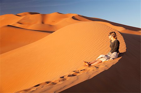 simsearch:862-03808150,k - Oman, Empty Quarter. Une jeune femme montres le soleil descendre sur les dunes. Photographie de stock - Rights-Managed, Code: 862-03808167