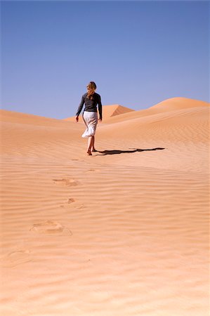 simsearch:862-05998271,k - Oman, Empty Quarter. A tourist strides off into the endless dunes. Stock Photo - Rights-Managed, Code: 862-03808185