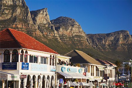 Restaurants on Victoria Road with Twelve Apostles in background, Camps Bay, Cape Town, Western Cape, South Africa Foto de stock - Direito Controlado, Número: 862-03808351