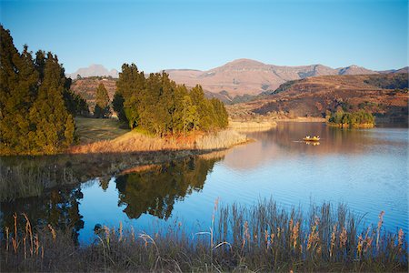 sudafricano (lugares y cosas) - Fishing boat on lake with Drakensberg mountains in background, Ukhahlamba-Drakensberg Park, KwaZulu-Natal, South Africa Foto de stock - Con derechos protegidos, Código: 862-03808435
