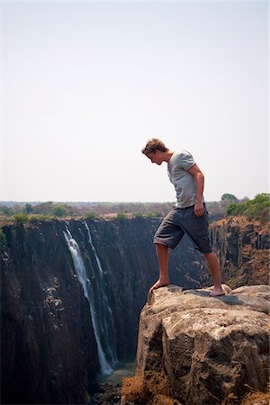 Zimbabwe, Victoria Falls. Un homme regarde par-dessus le bord des chutes Victoria. Photographie de stock - Rights-Managed, Code: 862-03808822