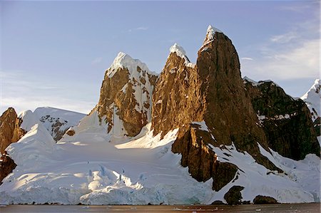 Antarctica, Booth Island, Lemaire Channel.At the northern end of Lemaire Channel is a pair of tall, rounded and often snow capped peaks known as Unas Tits.Known as Kodak Gap, this narrow waterway flows between the 3,000 foot peaks of Booth Island and the peninsula. Foto de stock - Con derechos protegidos, Código: 862-03820163