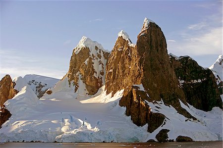 simsearch:862-03288559,k - Antarctica, Booth Island, Lemaire Channel.At the northern end of Lemaire Channel is a pair of tall, rounded and often snow capped peaks known as Unas Tits.Known as Kodak Gap, this narrow waterway flows between the 3,000 foot peaks of Booth Island and the peninsula. Stock Photo - Rights-Managed, Code: 862-03820163