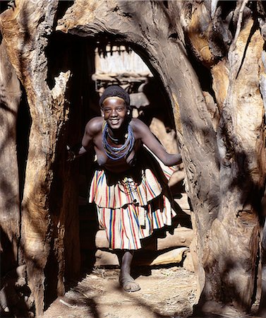 simsearch:862-03353998,k - Une jeune femme à l'entrée d'un homestead de Konso sud-ouest Ethiopia.The konso ont une grande affinité pour le bois et surround troncs et branches Pierre, grand arbre, chaque maison et spécial veiller à sélectionner les formes plus agréables de leurs entrées. Photographie de stock - Rights-Managed, Code: 862-03820417