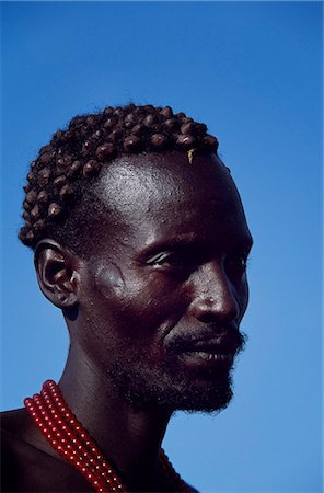 simsearch:862-03820406,k - The distinctive hair style of this Dassanech man, achieved using a combination of clay, animal fat and ochre, signifies that he has killed a man recently. Much the largest of the tribes in the Omo Valley numbering around 50,000, the Dassanech, also known as the Galeb, Changila or Merille, are Nilotic pastoralists and agriculturalists. Stock Photo - Rights-Managed, Code: 862-03820433