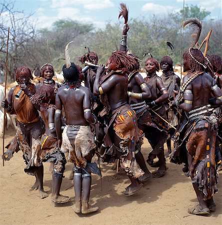 pastoralist - Hamar women dance, sing and blow small tin trumpets during a Jumping of the Bull ceremony.The semi nomadic Hamar of Southwest Ethiopia embrace an age grade system that includes several rites of passage for young men.The most elaborate of them and the most important is the Jumping of the Bull ceremony when a youth attains full manhood and is permitted to marry. Stock Photo - Rights-Managed, Code: 862-03820467