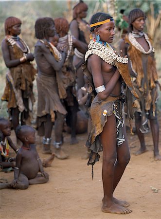 An attractive Hamar girl in traditional dress.The Hamar are semi nomadic pastoralists whose women have striking styles of traditional dress. Skins are widely used for clothing and cowrie shells are popular adornments yet the sea is 500 miles from their home Stock Photo - Rights-Managed, Code: 862-03820462