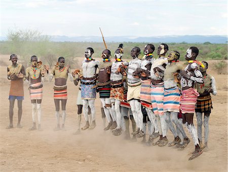 Karo men dance in line by jumping high in the air, legs straight.Even while dancing, they each keep hold of their wooden stools, which double as pillows at night.The Karo excel in body art. Before dances and ceremonial occasions, they decorate themselves elaborately using local white chalk, pulverised rock and other natural pigments. Stock Photo - Rights-Managed, Code: 862-03820493