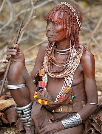 simsearch:841-02916988,k - A Hamar woman at a Jumping of the Bull ceremony.The Hamar are semi nomadic pastoralists of Southwest Ethiopia whose women wear striking traditional dress and style their red ochred hair mop fashion.The Jumping of the Bull ceremony is a rite of passage for young men. Stock Photo - Rights-Managed, Code: 862-03820509