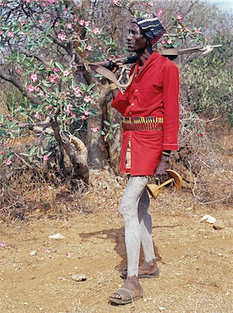 A Hamar man in a mix of traditional and modern dress.The Hamar are semi nomadic pastoralists who live in harsh country around the Hamar Mountains of Southwest Ethiopia.Their whole way of life is based on the needs of their livestock. Cattle are economically and culturally their most important asset. Stock Photo - Rights-Managed, Code: 862-03820572