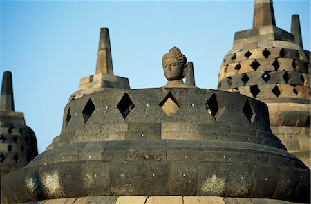 simsearch:862-07910016,k - Grillagees stupas sur les terrasses supérieures, temple de Borobudur, Java, Indonesia.Ranking avec Pagan et Angkor comme l'un des plus grands monuments du sud-est asiatiques, Borobodor, est une énorme construction majestueusement sur une colline surplombant des champs de verdure luxuriantes et les collines lointaines, 42 km au nord-ouest de Yogyakarta. Photographie de stock - Rights-Managed, Code: 862-03820594