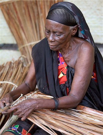 A Swahili woman in Lamu makes makuti, a coconut palm thatch used extensively as a roofing material on houses all along the East African Coast.Situated 150 miles north northeast of Mombasa, Lamu town dates from the 15th century AD. Stock Photo - Rights-Managed, Code: 862-03820769