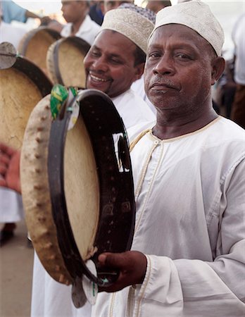 simsearch:862-03731544,k - Les hommes musulmans maintient le rythme avec des tambourins lors d'un spectacle de la Shabuwani le long du front de mer de la ville de Lamu.Situé à 150 km au nord nord-est de Mombasa, ville de Lamu datant du 15ème siècle de notre ère. Photographie de stock - Rights-Managed, Code: 862-03820774