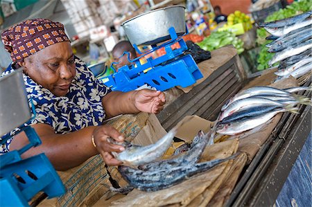 selling fish - Mozambique, Maputo.A large African lady lays out fresh fish on her stall in the Central Makret in Maputo.The Central Market, commonly known as Mercardo Central.The market is a good place to buy a variety of fresh and frozen fish aswell as vegetables, fruit, carvings, and baskets. Stock Photo - Rights-Managed, Code: 862-03820879