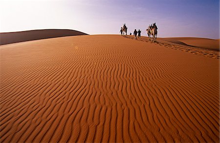 Niger, Tenere Desert.Camel Caravan travelling through the Air Mountains & Tenere Desert.This is the largest protected area in Africa, covering over 7.7 million hectares. Fotografie stock - Rights-Managed, Codice: 862-03820898