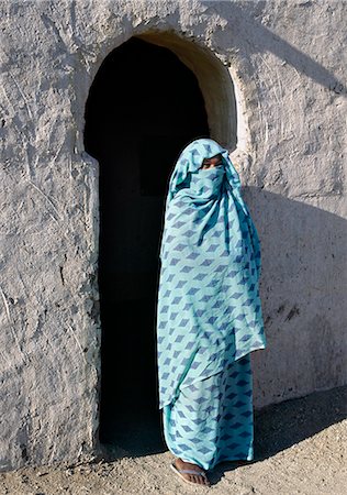 sudan - A Nubian woman, her face covered by her headscarf to denote her Muslim belief, stands outside the verandah of her home.The style of verandah arch is typical of the Nubian people. Foto de stock - Con derechos protegidos, Código: 862-03820976