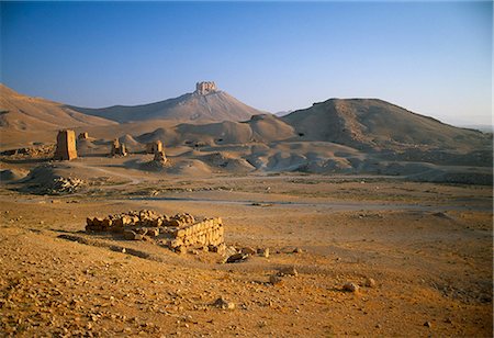 View from The Valley of the Tombs with Mamluk era Fakhr al Din abn Ma ani Citadel visible in the background, Palmyra.The Valley of the Tombs, beyond the Camp if Diocletian to  the west of the city, contains a large number of tomb towers, each built for a specific family. Stock Photo - Rights-Managed, Code: 862-03820985