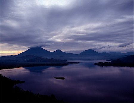 simsearch:841-03672196,k - Lake Mutanda is possibly the most beautiful lake of the Great Lakes region.It has an idyllic backdrop of five volcanoes of the Virunga chain, which straddle the Uganda-Rwanda border. Stock Photo - Rights-Managed, Code: 862-03821045