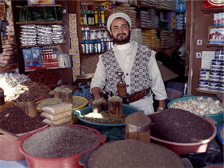 simsearch:841-02944802,k - Un commerçant yéménite à son étal de marché dans le vieux souk de Suq.The ou le marché central se trouve dans un labyrinthe de rues et les ruelles du centre de la vieille ville. Une grande variété de marchandises est offert en vente encore les secteurs spécialisés dans certains produits faire shopping relativement facile. Photographie de stock - Rights-Managed, Code: 862-03821095