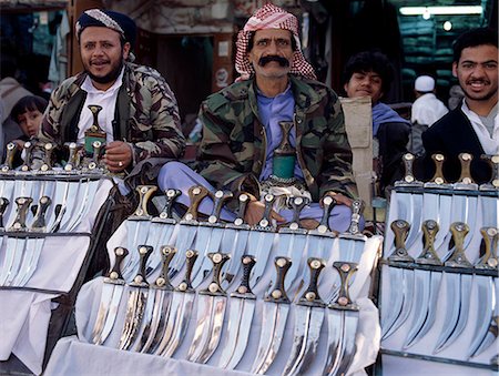 simsearch:862-03437266,k - Surrounded by a massive 20 to 30 foot high wall, old Sana a is one of the worlds oldest inhabited cities.The suq or central market is located in a labyrinth of streets and alleyways in the centre of the old city. Every male Yemeni wears a jambiya, a curved dagger, on a finely decorated belt.It is always worn in front of the body with the tip of the sheath pointing to the right. Stock Photo - Rights-Managed, Code: 862-03821091