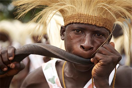 simsearch:862-03887439,k - Bujumbura, Burundi. Un perormer de traditonal souffle une corne lors d'une fête dans la ville. Photographie de stock - Rights-Managed, Code: 862-03887460